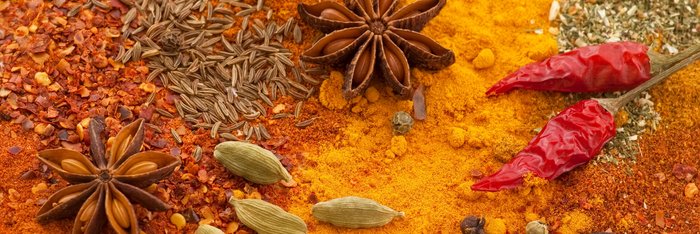 Gelb und Orange farbene Gewürze in Pulver und Ursprungsform