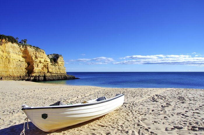 Ein kleines Fischerboot am Strand an der Algarve, Portugal