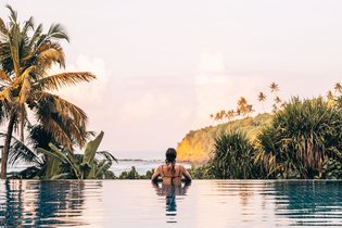 Eine Frau im Pool Blick auf das Meer
