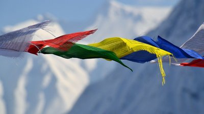 yoga-urlaub-nepal-fahnen-berge-schnee Bunte Fahnen vor schneebedeckten Bergen