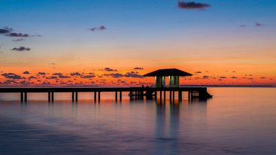 Sonnenuntergänge tauchen die Malediven und das Meer in ein orange, rötliches Licht