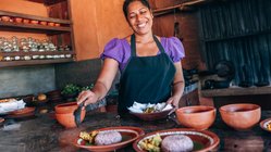 Eine Frau richtet Teller mit Reis an