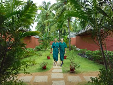 Entspannter Spaziergang nach der Ayurveda-Behandlung durch den Garten des Nattika Beach Resorts