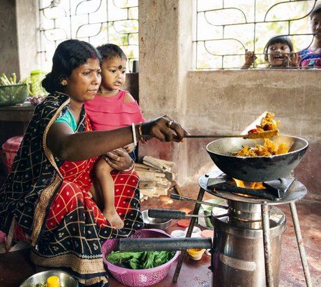 Frau und Kind sitzen vor einem effizienten Holzvergaserofen