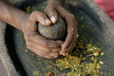 Die ayurvedischen Kräuter werden frisch gemörsert