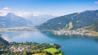 Ein blauer See zwischen Bergen und einer Stadt