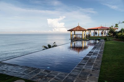 Schwimmen Sie im Infinity Pool und blicken Sie dabei auf das Meer