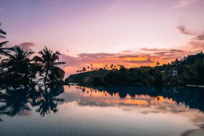 Ein farbenfroher Sonnenuntergang, der sich im hauseigenen Pool spiegelt