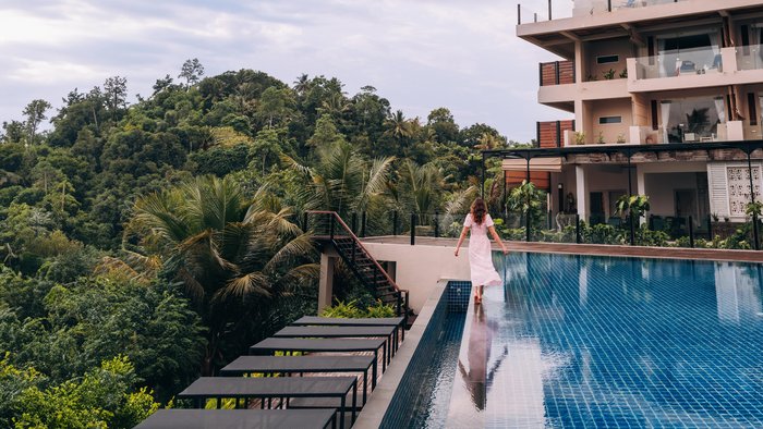 Eine Frau läuft auf dem Rand eines Pools