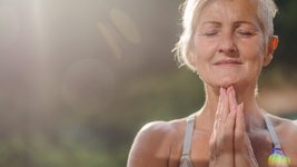Eine Seniorin hält die Hände im Anjali Mudra