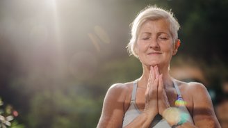 Eine Seniorin hält die Hände im Anjali Mudra