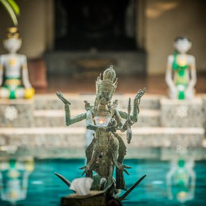Eine balinesische Statue vor einer Resortanlage