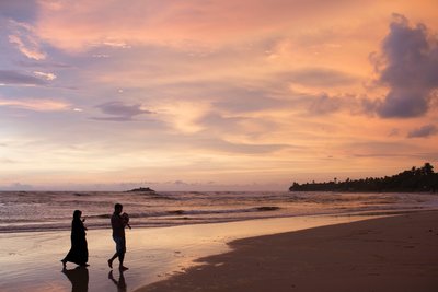 Am Strand den farbenfrohen Sonnenuntergang betrachten