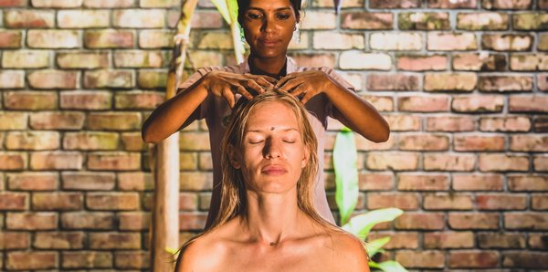 Eine Frau erhält eine ayurvedische Kopfmassage