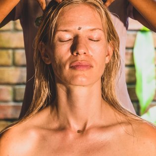 Eine blonde Frau bekommt den Kopf massiert