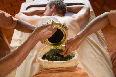 Eine Kativasthi Behandlung mit warmem Kräuter-Öl kann bei Rückenschmerzen Linderung verschaffen