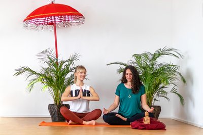 Zwei Frauen meditieren auf einer Yogamatte