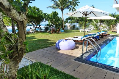 Im Garten des Sithnara Ayurveda Resorts spenden Kokospalmen Schatten