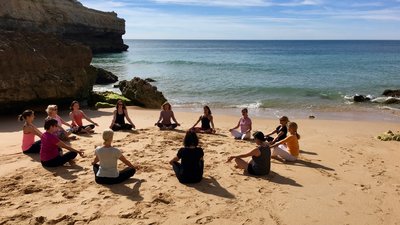 Frauen im Schneidersitz in einem Kreis am Strand