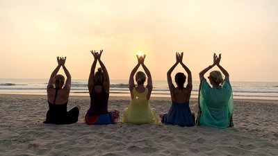 Yoga Gruppe am Strand bei Sonnenuntergang