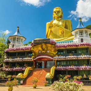 Goldene Buddha-Statue die auf einem bunten Tempel sitzt 