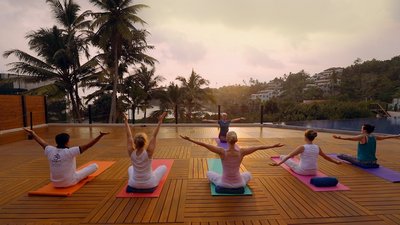 Yoga mit Blick wiegende Palmen und den weiten Ozean auf der Terrasse des Ayurvie